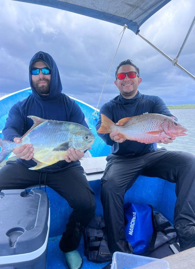 Clients avec leurs prises sur un bateau dans la baie de Jiquilisco